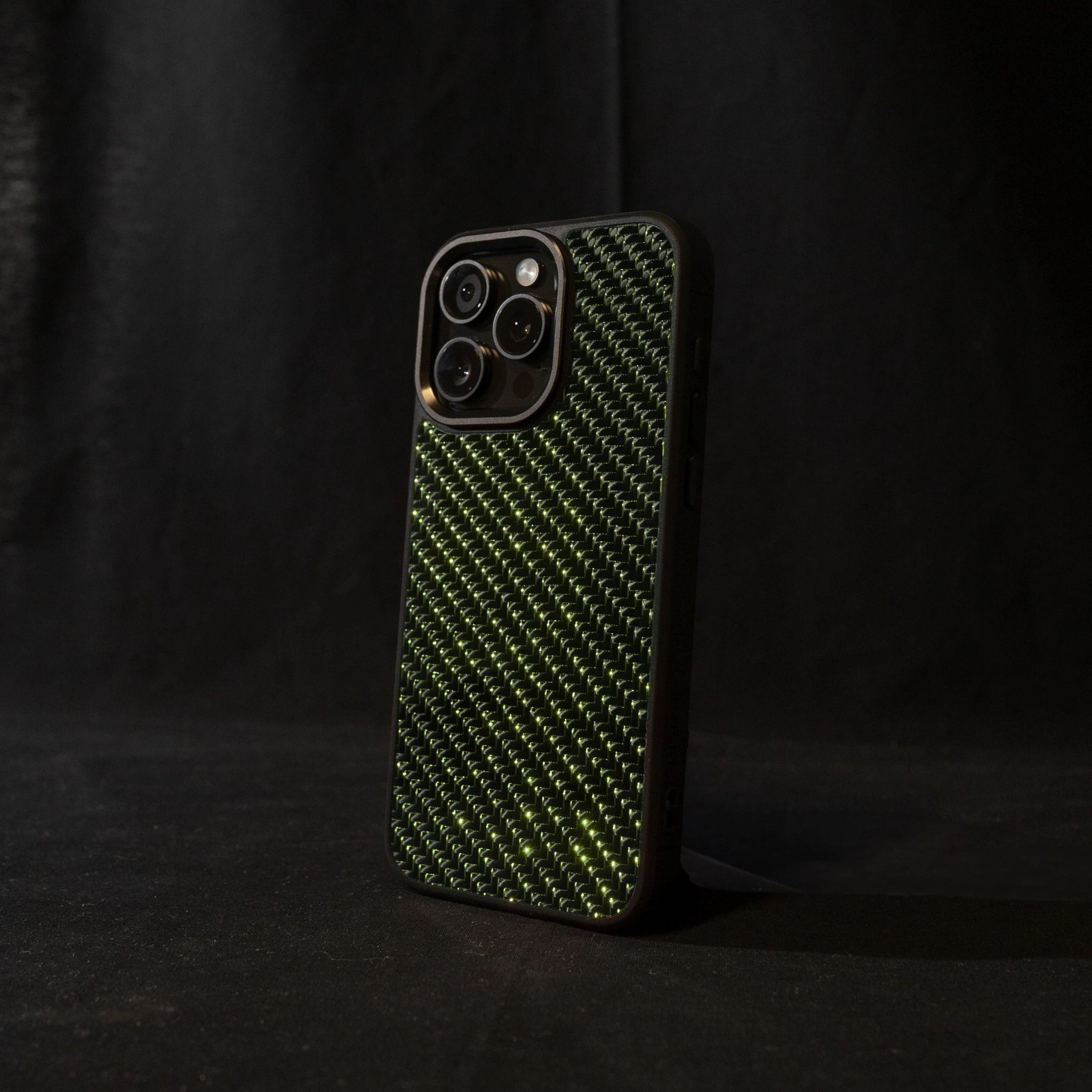 Green carbon fiber phone case on a black background angled sideways