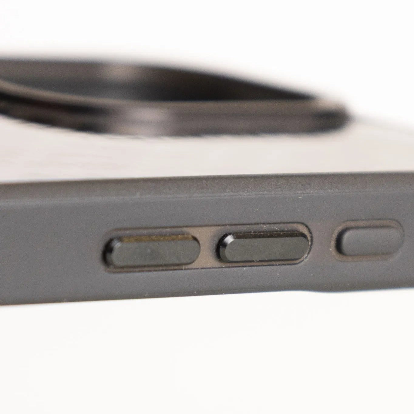 Close-up of aluminum side buttons on carbon fiber iPhone case for premium feel and precision fit.