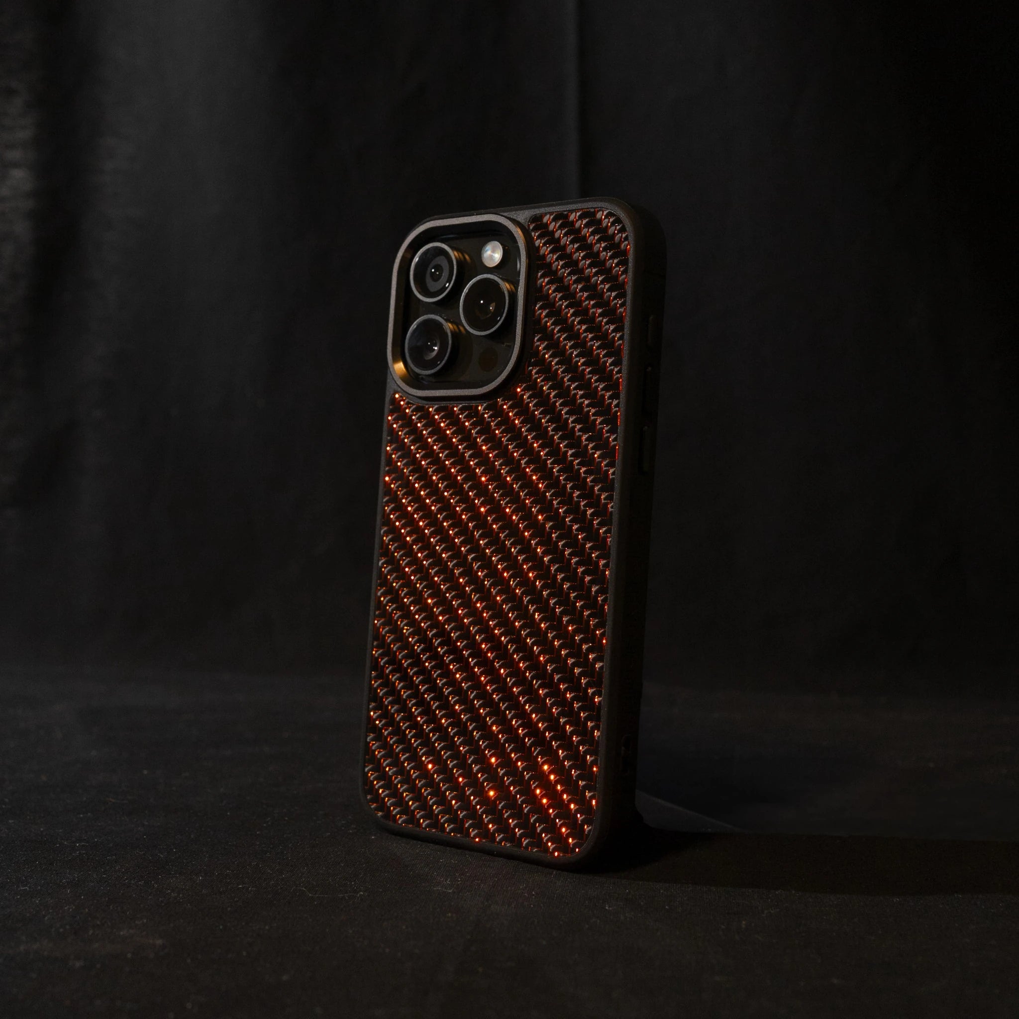 Red carbon fiber phone case on a black background angled sideways