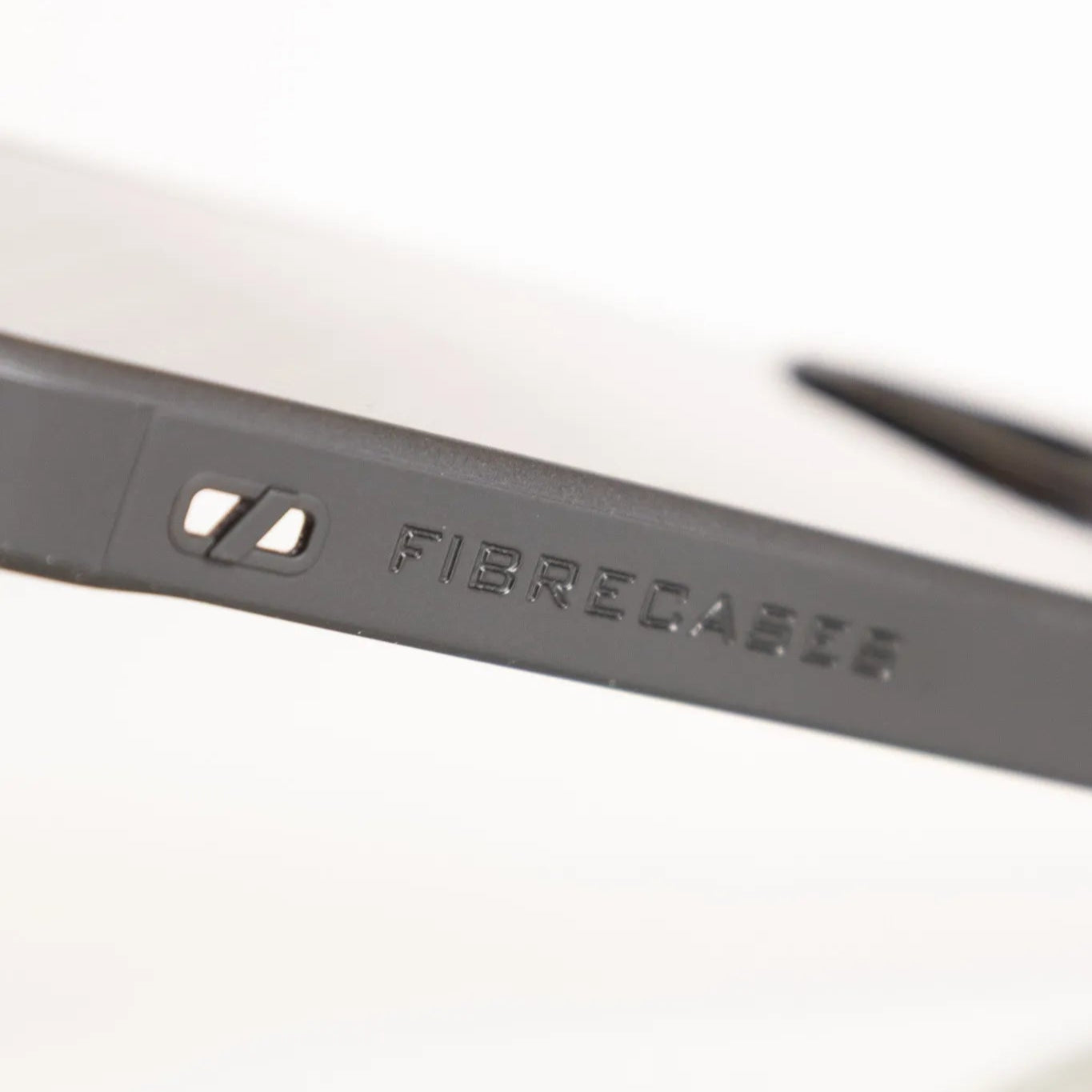 Side view of carbon fiber phone case showing embossed FIBRECASES logo branding.